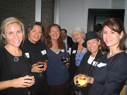 Group of women smiling, holding wine glasses